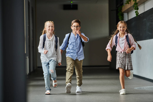 grupo de crianças pequenas alegremente andando por um corredor brilhante - Foto, Imagem