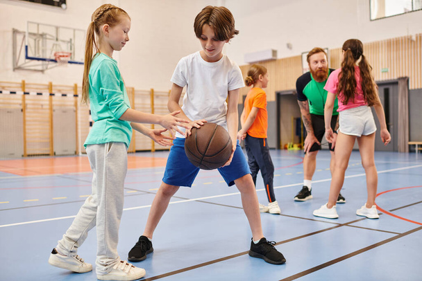 Μια ποικιλόμορφη ομάδα μικρών παιδιών που παίζουν μπάσκετ με ενθουσιασμό και ενέργεια σε ένα ζωντανό περιβάλλον. - Φωτογραφία, εικόνα