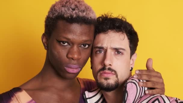 close-up video van twee multi-etnische transgender en homoseksuele mannen kijken naar de camera met een serieuze blik - Video