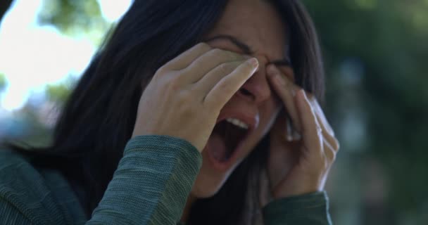 Mujer cansada bostezando y frotando los ojos y la cara con las manos de pie fuera en super cámara lenta 800 fps, emoción fatiga - Metraje, vídeo