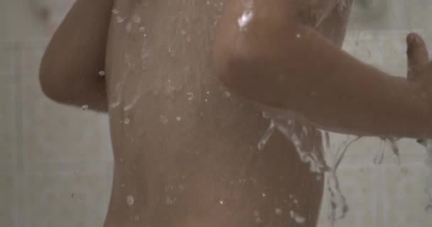 Vízcseppek hullanak lassított felvételben a gyermek bőrébe és testébe a zuhanyfej alatt szuper lassított felvételben 800fps - Felvétel, videó