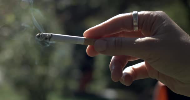 Zbliżenie strony trzymającej papierosa uchwyconego w zwolnionym tempie 800 fps - Materiał filmowy, wideo