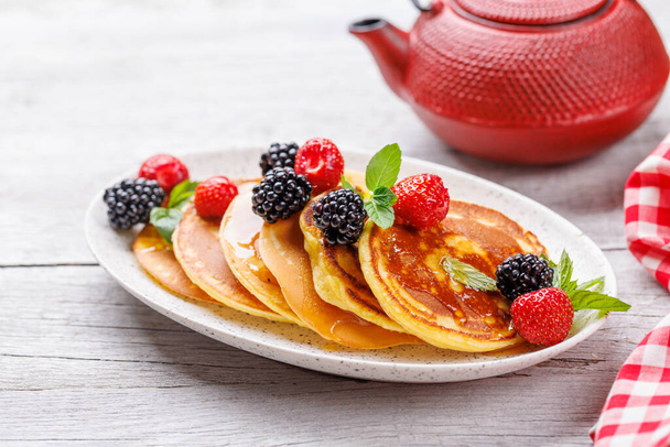 Вкусные домашние блины с ягодами и медовым сиропом - Фото, изображение