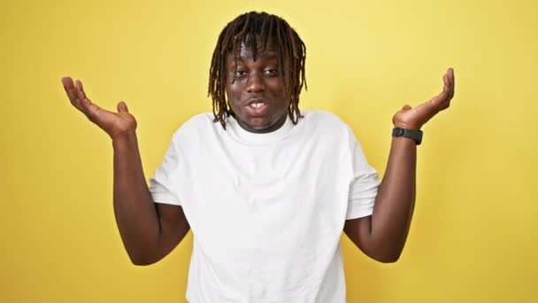 Afro-Amerikaanse man staan clueless over geïsoleerde gele achtergrond - Video