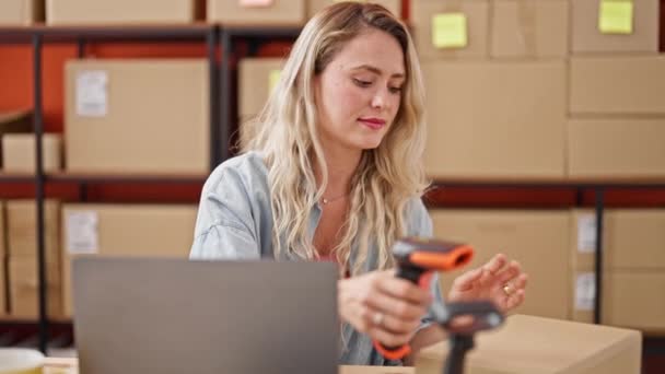Jonge blonde vrouw e-commerce zakenman scanning pakket op kantoor - Video