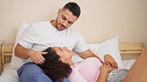 Hombre y mujer pareja sentado en la cama besándose de la mano en el dormitorio - Metraje, vídeo