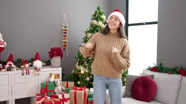Молода красива іспаномовна жінка святкує різдвяні танці вдома - Кадри, відео