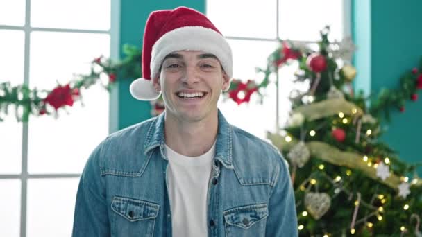 Νεαρός Ισπανός που φοράει χριστουγεννιάτικο καπέλο χαμογελώντας στο σπίτι - Πλάνα, βίντεο