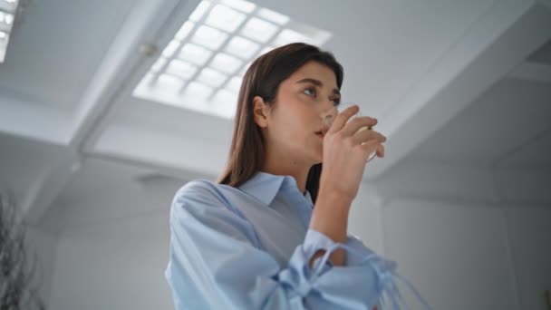 Pretty woman drinking water in office closeup. Beautiful girl taking break sip tea in modern business center. Thoughtful businesswoman holding beverage cup looking camera. Break relaxation concept. - Footage, Video