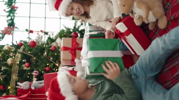 Adorabile ragazzo e ragazza che festeggiano il Natale disimballaggio regalo a casa - Filmati, video