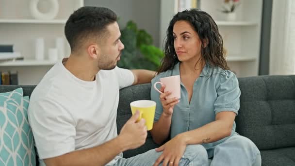 Hombre y mujer pareja sentado en sofá beber café besos en casa - Imágenes, Vídeo