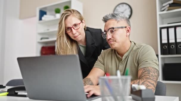 Férfi és női üzletemberek együtt dolgoznak laptoppal az irodában - Felvétel, videó