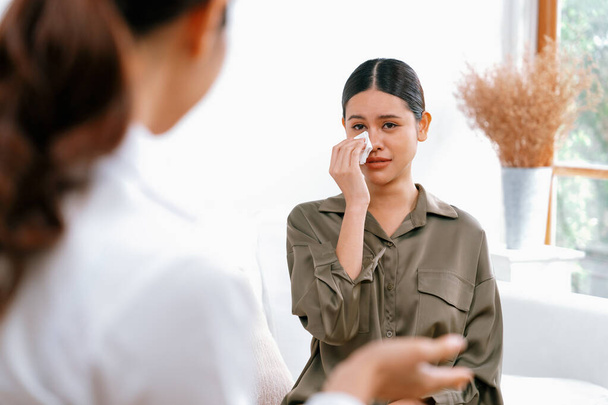 Sad PTSD woman patient in uttermost therapy for mental health with psychologist, depression or grief after life failure. Frustrated trauma young woman talking to a psychologist about emotion in clinic - Photo, Image
