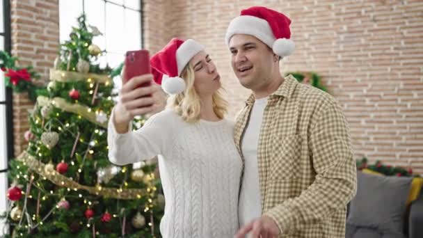 Noel 'i kutlayan erkek ve kadın çifti evde akıllı telefonlardan selfie çekiyor. - Video, Çekim