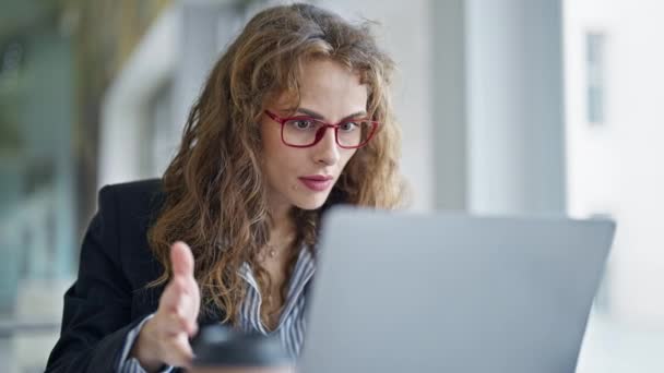 Młoda kobieta pracownik biznesu za pomocą laptopa pracy z gestem zwycięzcy w biurze - Materiał filmowy, wideo