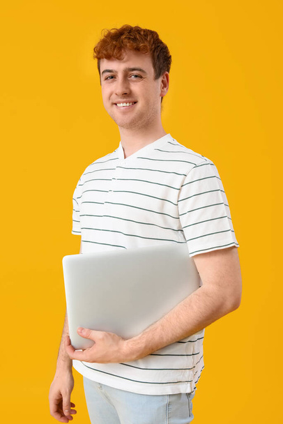 Male programmer with laptop on yellow background - Photo, Image