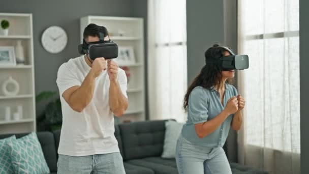 Kadın ve erkek evde sanal gerçeklik gözlüğü kullanarak video oyunu oynuyorlar. - Video, Çekim