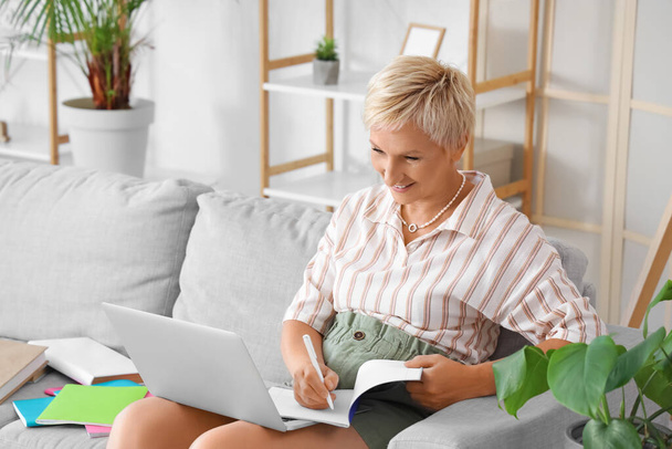 Mature woman learning English language online at home - Фото, изображение