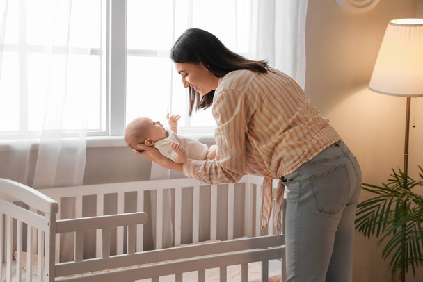 Young woman with her little baby in bedroom - Photo, Image