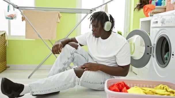 Африканський американець слухає музику, танцює в пральні - Кадри, відео