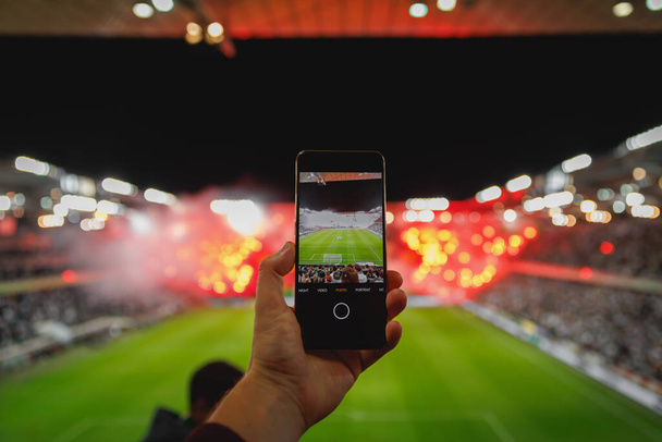 Photographie par téléphone portable de la performance du secteur des fans lors d'un match de football - Photo, image
