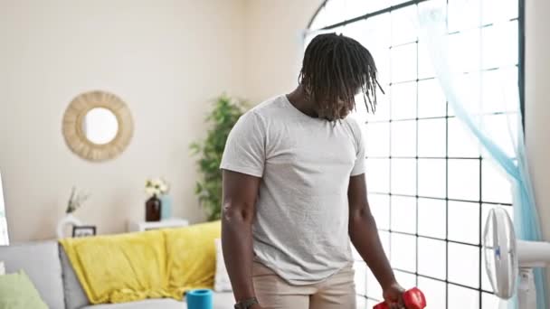 Hombre afroamericano usando mancuernas de entrenamiento en casa - Imágenes, Vídeo