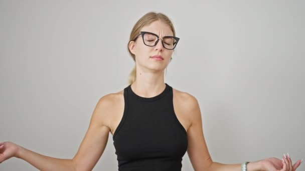 Junge blonde Frau bedeckt Ohren für Lärm schreit über isolierten weißen Hintergrund - Filmmaterial, Video