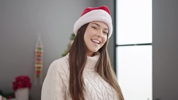 Genç ve güzel İspanyol kadın Noel ağacının yanında durmuş evde dans ediyor. - Video, Çekim