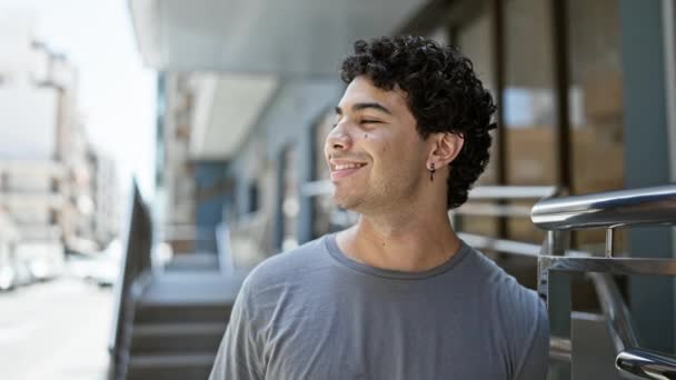 Молодий латинський чоловік посміхається впевнено дивлячись в сторону на вулиці
 - Кадри, відео