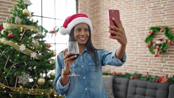 Mujer afroamericana hacer selfie por teléfono inteligente beber vino celebrando la Navidad en casa - Imágenes, Vídeo