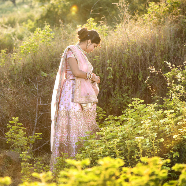 Portrait of beautiful bride wearing traditional clothing outside in nature at sunset. - Foto, immagini