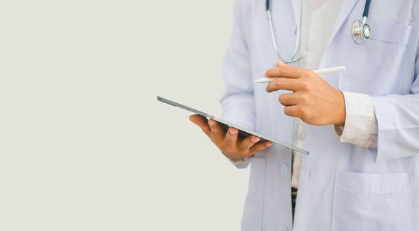 Portré orvos sztetoszkóppal és digitális tabletta áll magabiztosan készen az egészségügyi látogató a kórházban vagy a klinikán. - Fotó, kép