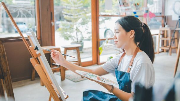 Dibujo de estudiante de arte con pintura de acuarela en lienzo haciendo algunos proyectos de arte en taller de estudio - Foto, imagen