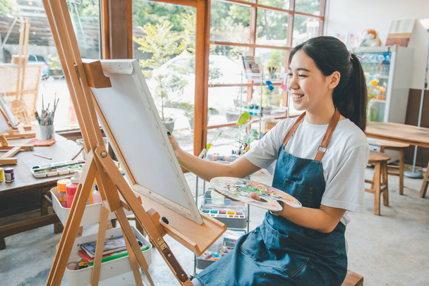Dibujo de estudiante de arte con pintura de acuarela en lienzo haciendo algunos proyectos de arte en taller de estudio - Foto, imagen