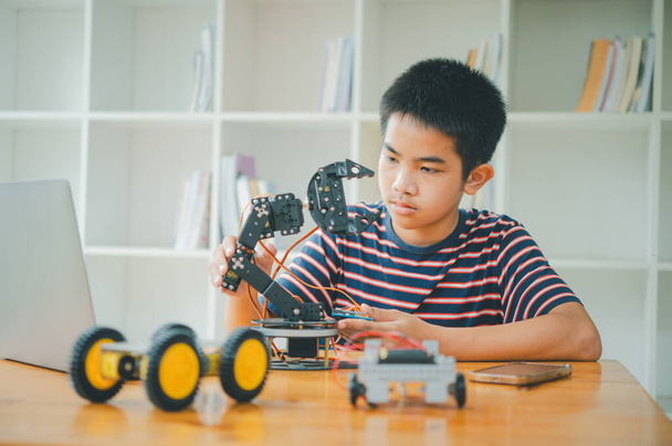 Aziatische jongen leren en bestuderen van het werk van technologie robots.homeschool en wetenschap voor tech project. spelen kinderen hobby vrije tijd levensstijl mensen speelgoed robotica technologie. - Foto, afbeelding