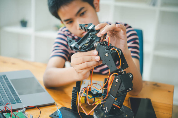 Asiático niño aprendiendo y estudiando el trabajo de la tecnología robots.homeschool y la ciencia para el proyecto tecnológico. jugar niños infancia hobby ocio estilo de vida personas juguetes robótica tecnología. - Foto, Imagen
