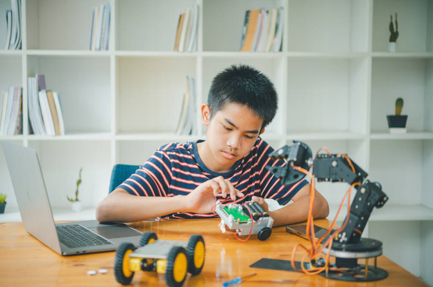 Ázsiai fiú tanul és tanul a munka a technológia robots.home iskola és a tudomány a tech projekt. játék gyermekkori gyerekek hobbi szabadidő életmód emberek játékok robotika technológia. - Fotó, kép
