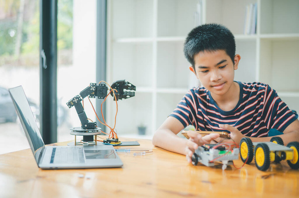 Ázsiai fiú tanul és tanul a munka a technológia robots.home iskola és a tudomány a tech projekt. játék gyermekkori gyerekek hobbi szabadidő életmód emberek játékok robotika technológia. - Fotó, kép