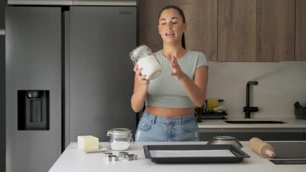 Caucasian young woman explaining butter cookies recipe to the camera. - Footage, Video