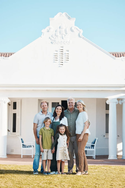 Happy big family, portrait and hug in new home on lawn, property or investment on outdoor grass. Parents, grandparents and children smile for moving in, house or happiness in real estate together. - Photo, Image