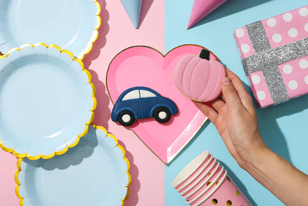 Κουτί δώρου, χάρτινα επιτραπέζια σκεύη και cookies σε μπλε και ροζ φόντο, κορυφαία προβολή - Φωτογραφία, εικόνα