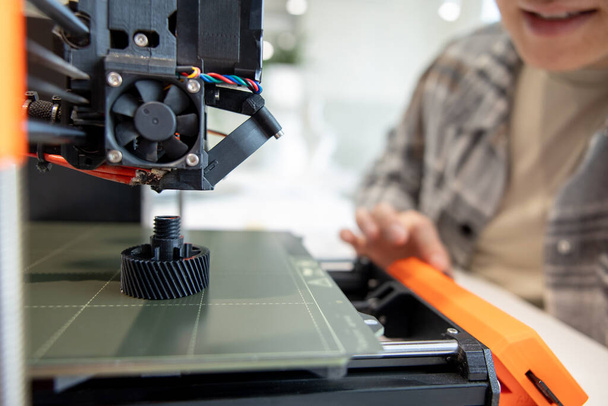 Closeup of man checking 3d printer, process of making things on 3d printer in laboratory. - Foto, afbeelding