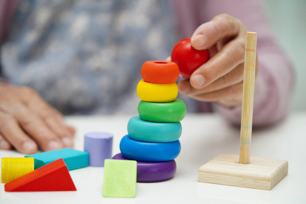 Asiatische ältere Frau spielt Puzzlespiel, um Gehirntraining für Demenz-Prävention, Alzheimer-Krankheit zu üben. - Foto, Bild