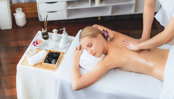 Caucasian woman customer enjoying relaxing anti-stress spa massage and pampering with beauty skin recreation leisure in day light ambient salon spa at luxury resort or hotel. Quiescent - Photo, Image