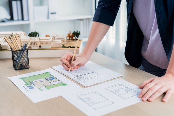 Mimar tasarımcının ofis masasındaki tasarım kağıdının üzerinde ev düzeni planlayan iç mimar el tasarımı. Mimar, kalem ve araçla evin iç düzenini dikkatlice çiz. Tekrarlama - Fotoğraf, Görsel