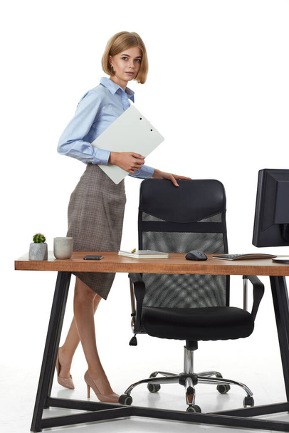 beautiful businesswoman in formal wear with clipboard in office - Foto, Imagen
