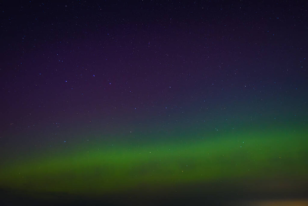 Lettische Aurora am Nachthimmel im Herbst. Ruhige Szene der nächtlichen Polarlichter, beleuchtete grüne Landschaft, sternenklare himmlische Schönheit. Ruhiger Nachthimmel, grüne Polarlichter, die himmlische Landschaft erleuchten - Foto, Bild