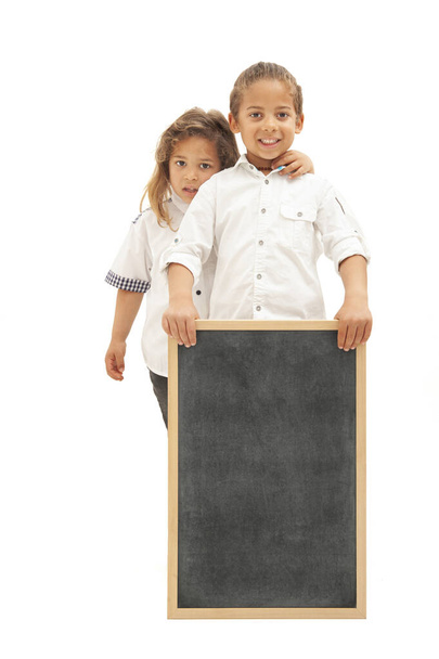 Inglese: Two multiethnic children with long hair hold a whiteboard in their hands, against a white background - Photo, Image