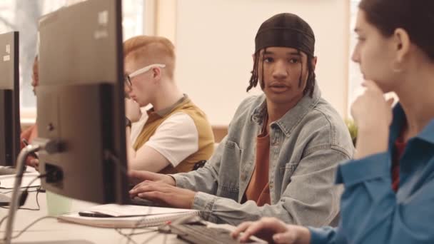 Cintura hacia arriba lentitud de los estudiantes universitarios multiculturales que estudian las TIC en las computadoras en el aula moderna - Metraje, vídeo