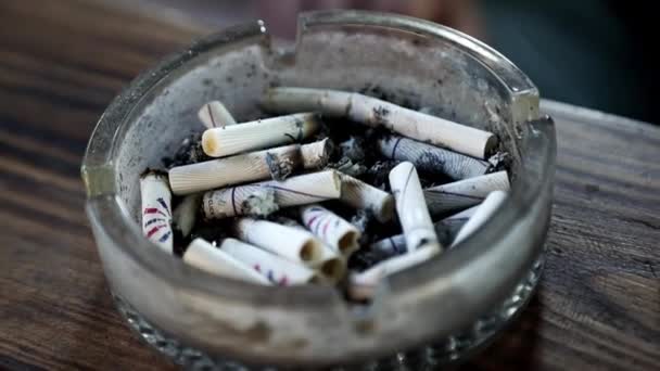 Mano de hombre sacude cenizas de cigarrillo en un cenicero - Imágenes, Vídeo